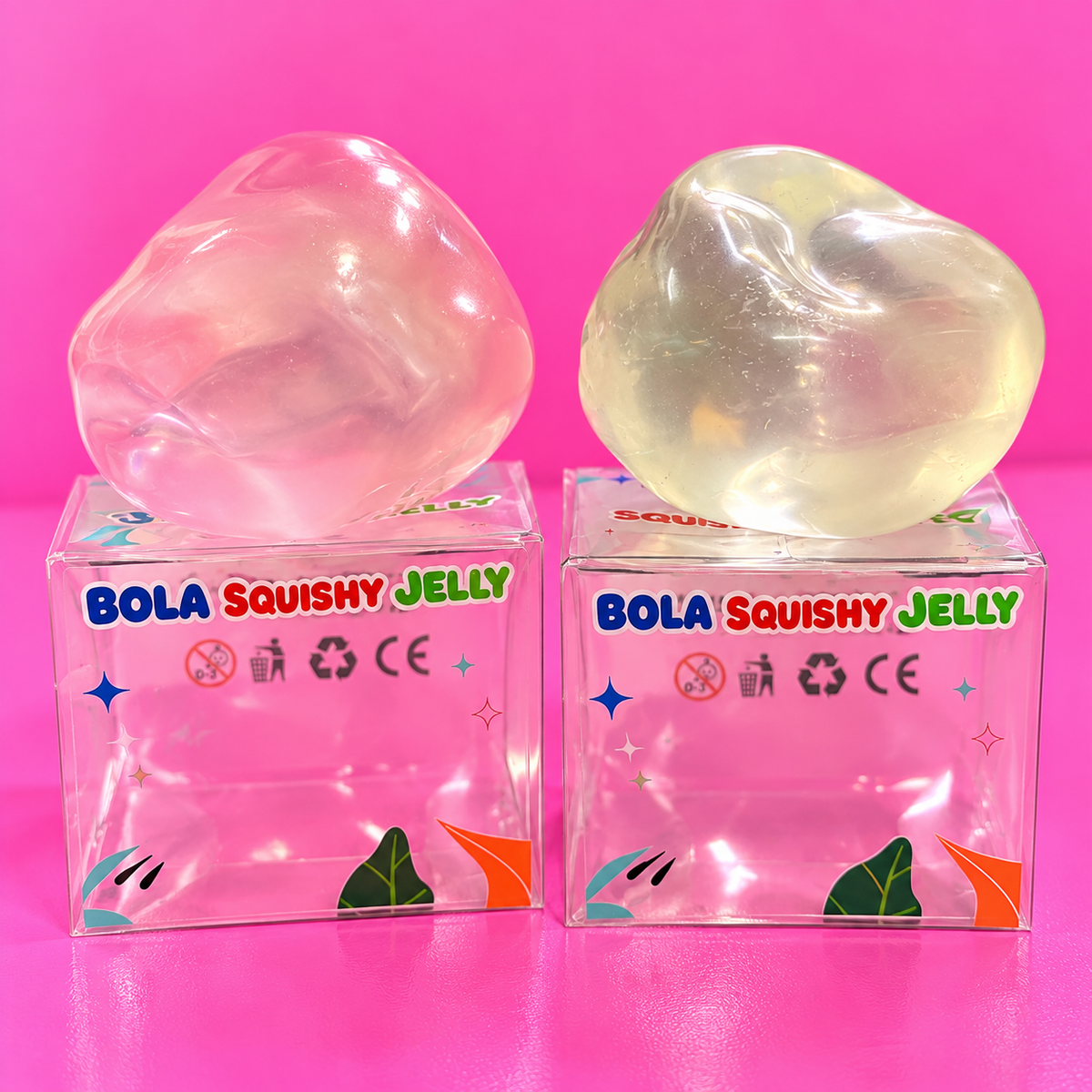 Moldable jelly filled squishy balls in pink and clear white on pink table